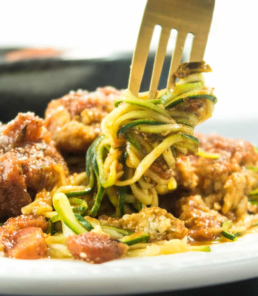 Zoodles with Cauliflower Meatballs being swirled with a fork