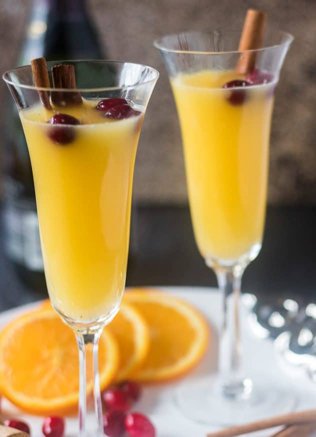 Mimosa in champagne glass with cinnamon sticks & cranberries