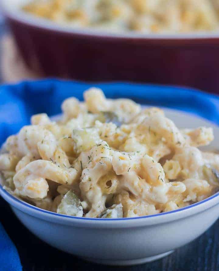 Baked Mac and Cheese with dill pickles in a white bowl.