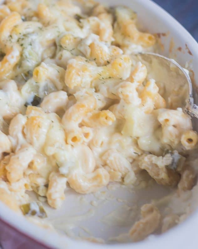 Baked Mac and Cheese with dill pickles in a creamy white garlic sauce in a casserole dish.
