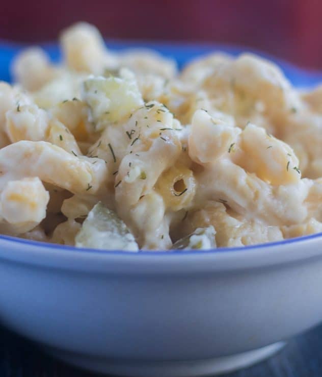 Baked Mac and Cheese in a white bowl with dill pickles.