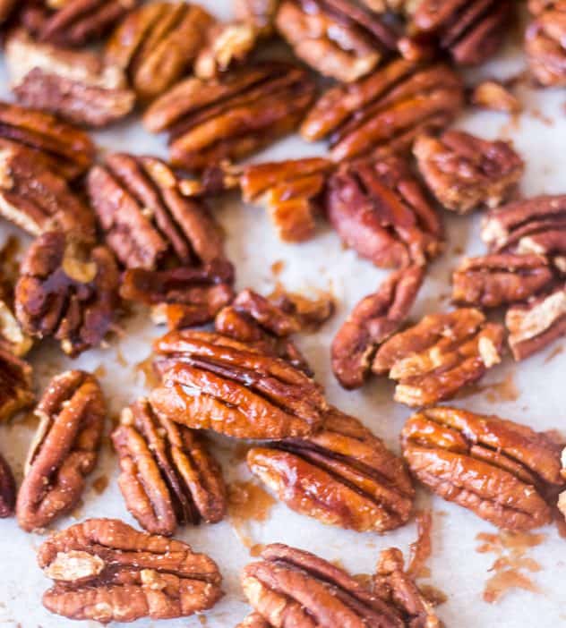 Maple Cinnamon Roasted Pecans on a sheet pan with parchment paper.