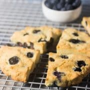 Blueberry Scones on a cooling rack with a bowl of blueberries