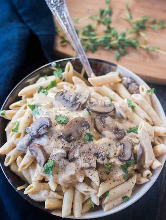 Mushroom Stroganoff in a bowl with a spoon garnished with parsley.