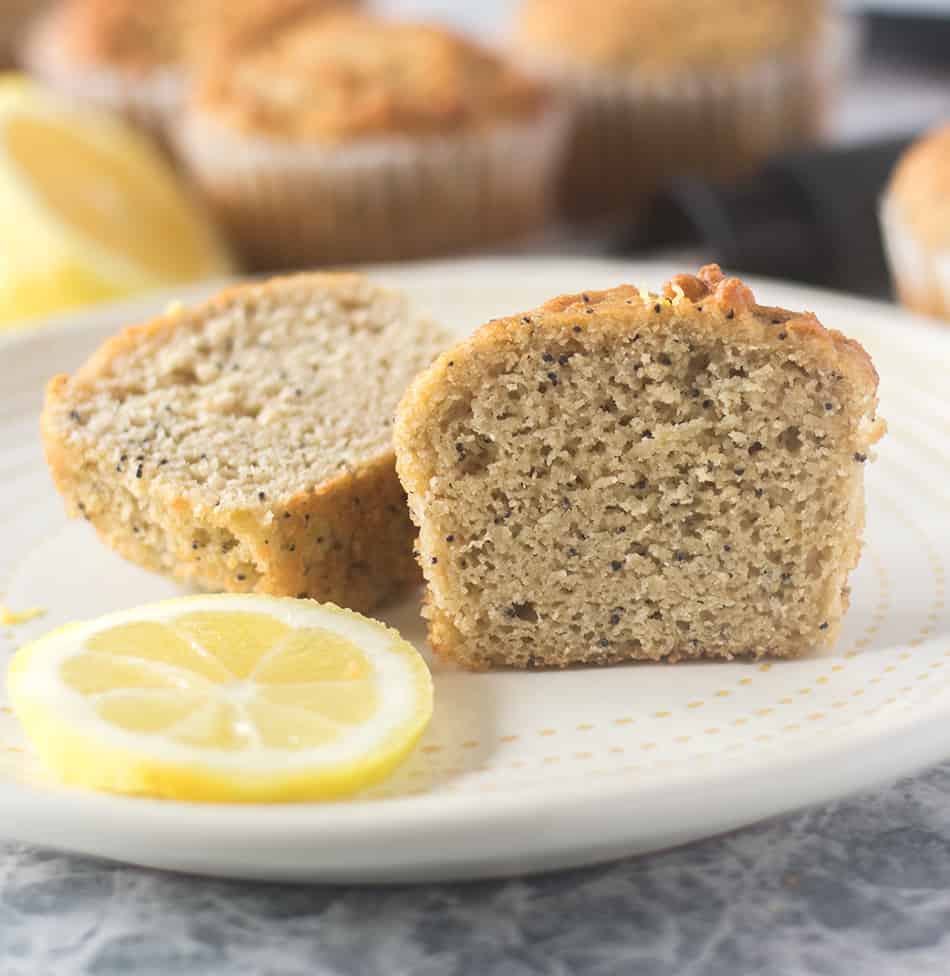 Lemon Poppy Seed Muffin cut in half on a plate with a lemon slice.