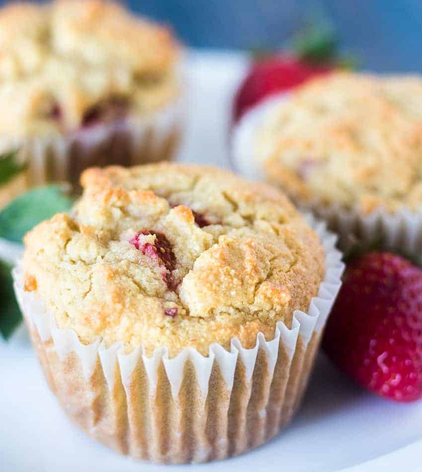 Strawberry Muffins on a white plate with fresh strawberries.