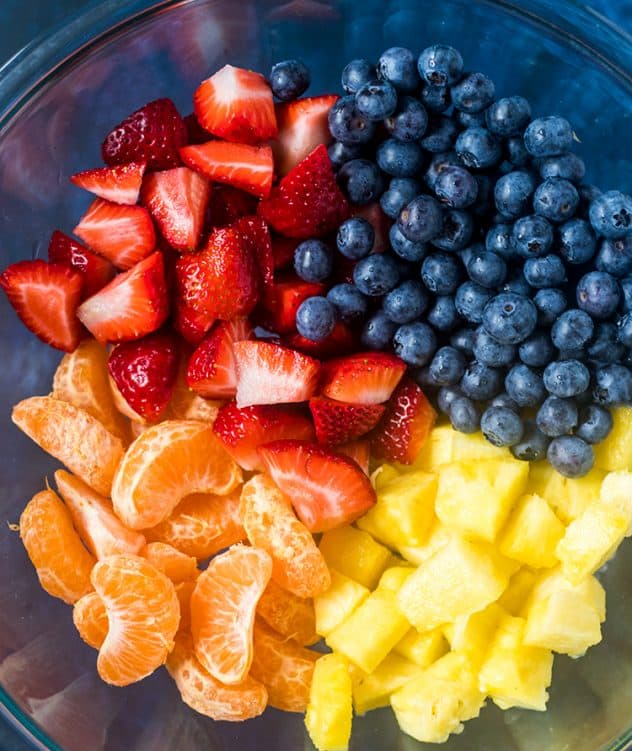 Blueberries, strawberries, mandarin oranges, and pineapple cut up in a bowl.