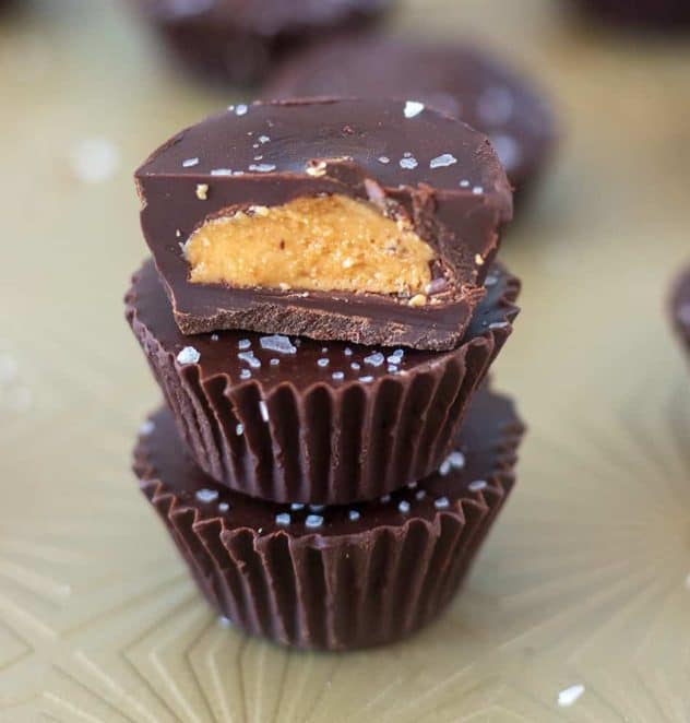 Dark Chocolate Cashew Nut Butter Cups stacked on top of each other with one cut in half.