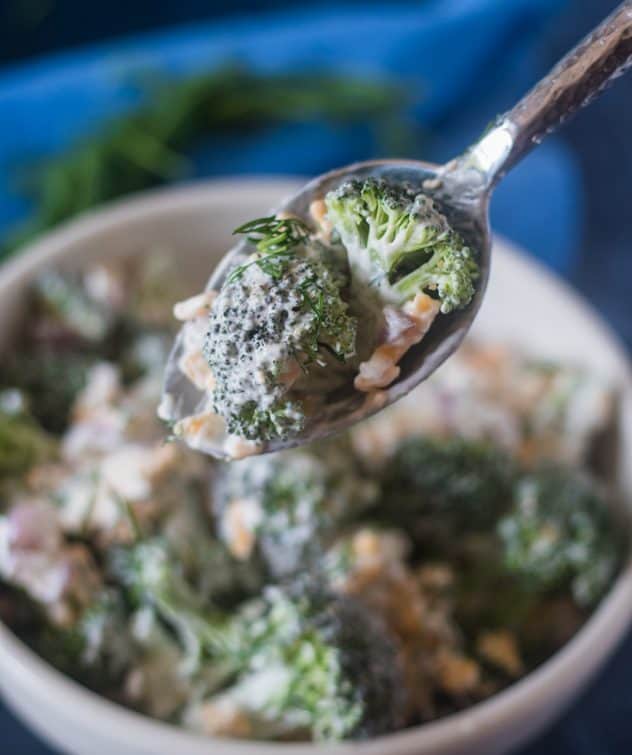 Broccoli Salad on a silver serving spoon.