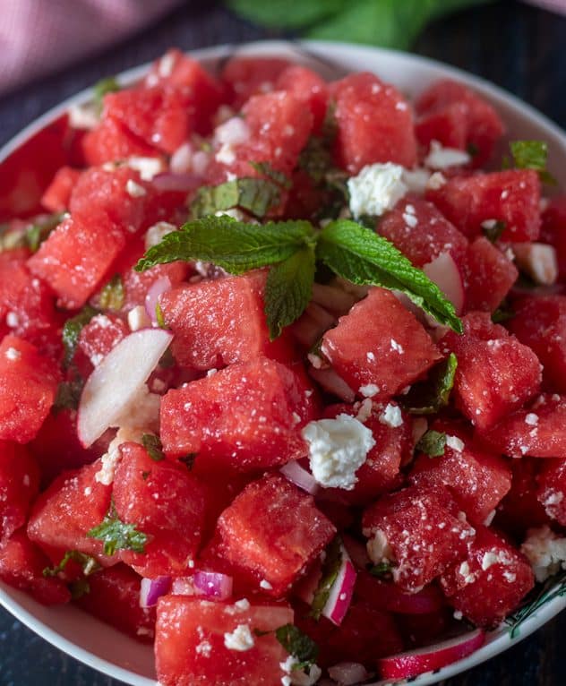Watermelon Feta Mint Salad in a bowl topped with fresh mint leaves.