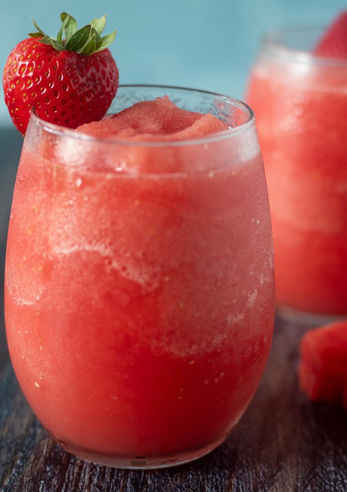 Watermelon Strawberry Wine Slushies in a glass garnished with a strawberry.