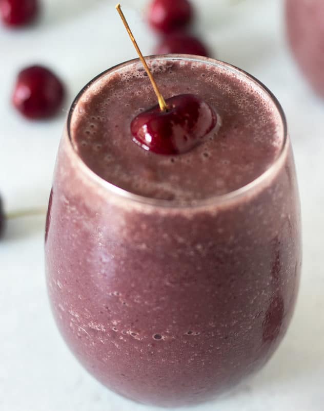 Cherry Smoothie in glass with cherry on top and cherries in background