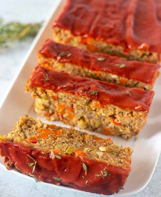 Lentil Loaf on a white serving plate garnished with fresh thyme.