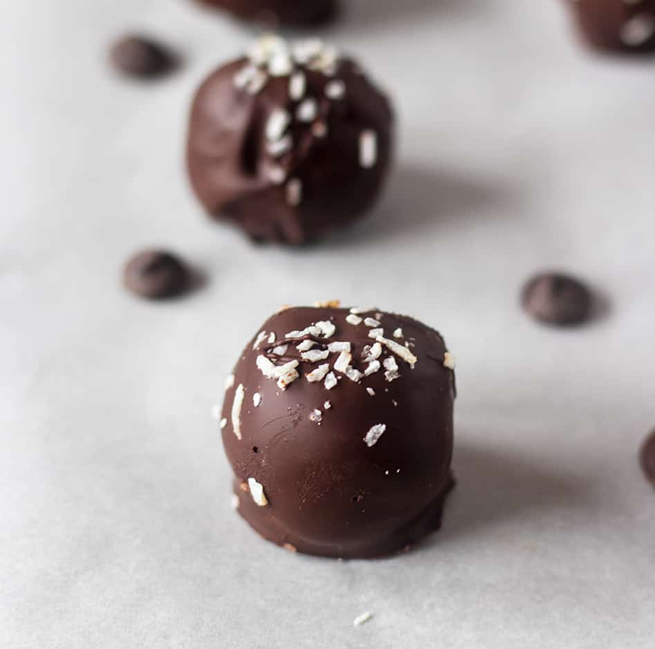 chocolate coconut balls on parchment lined baking sheet