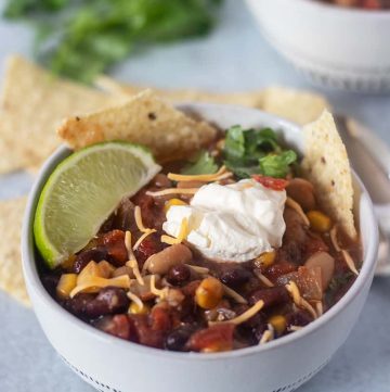slow cooker taco soup in a bowl topped with cheese and sour cream