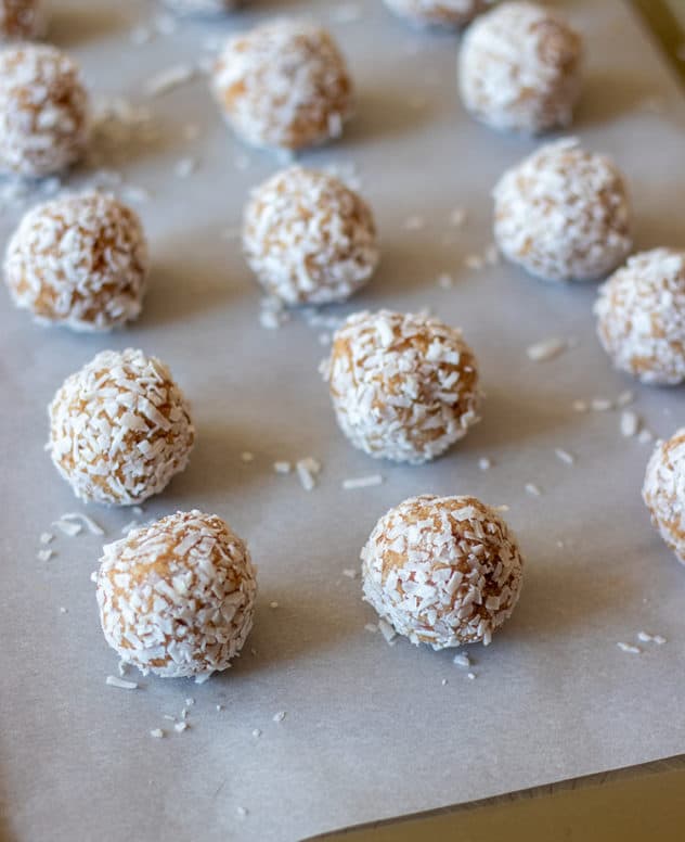 Snowball cookies rolled in coconut on baking sheet