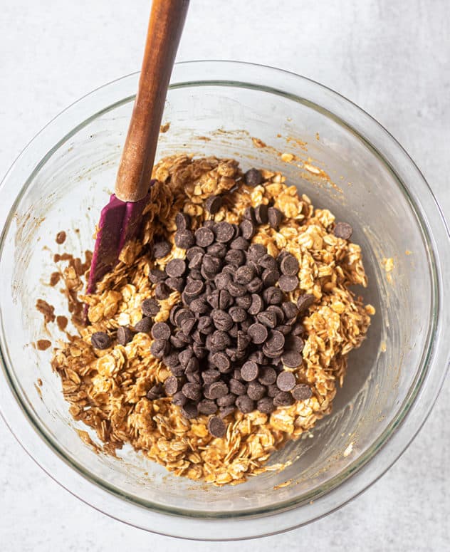 breakfast cookies in a mixing bowl and chocolate chips being folded in.