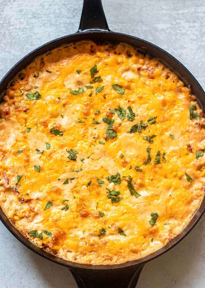 mexican corn dip in a cast iron skillet topped with cilantro