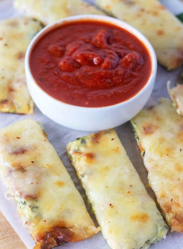 Baked Zucchini Sticks with a bowl of marinara sauce for dipping