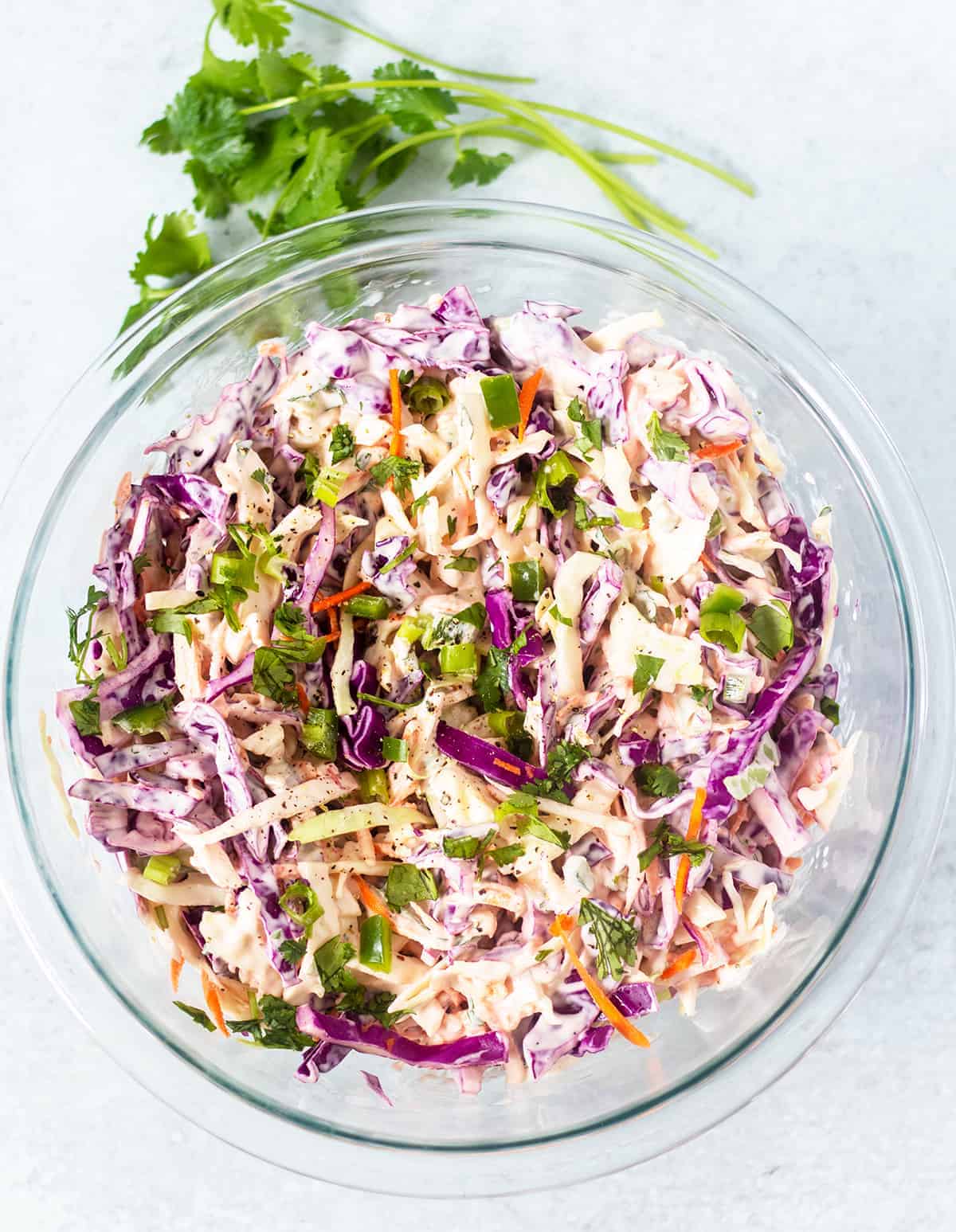 cilantro lime slaw in clear glass mixing bowl