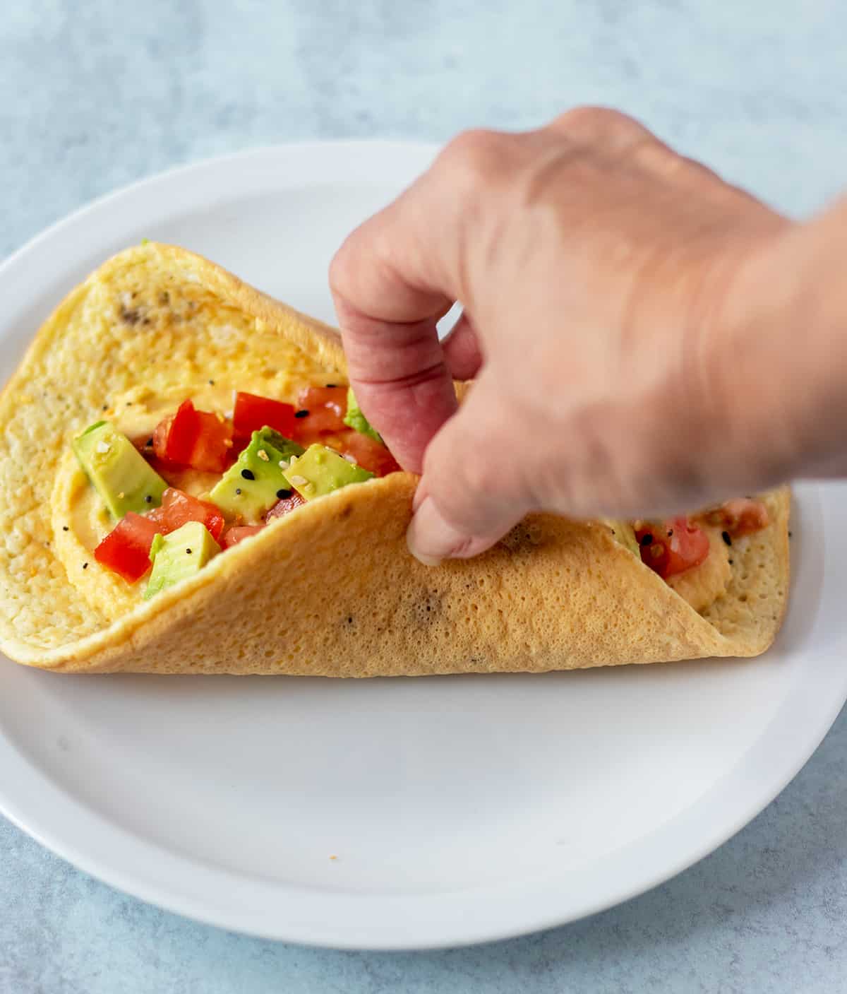 Egg wraps topped with hummus, avocado and tomatoes
