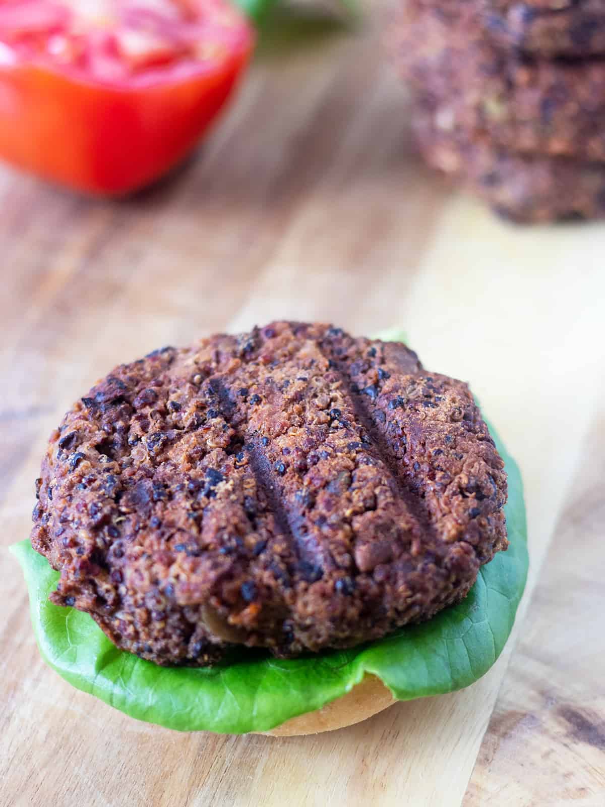 Grilled Black Bean Quinoa Burger topped on a bun with lettuce