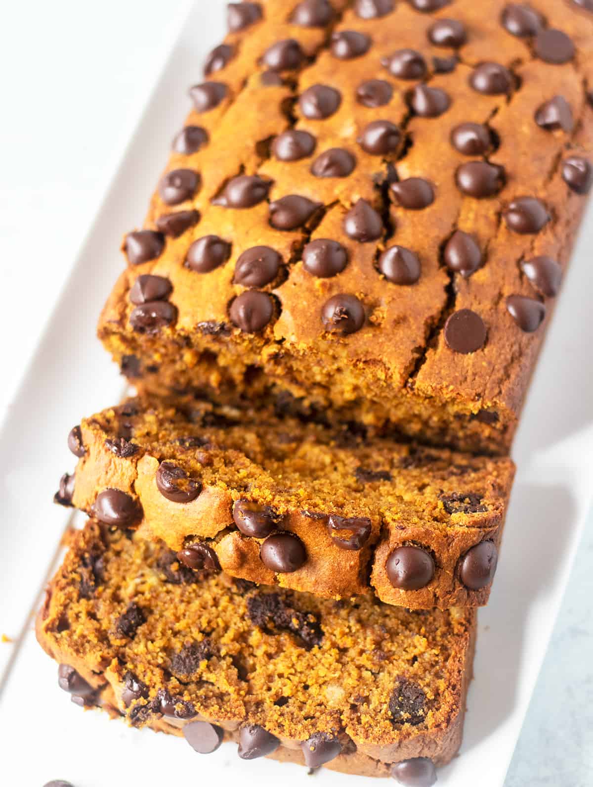 pumpkin chocolate chip bread on a white serving platter that's been sliced
