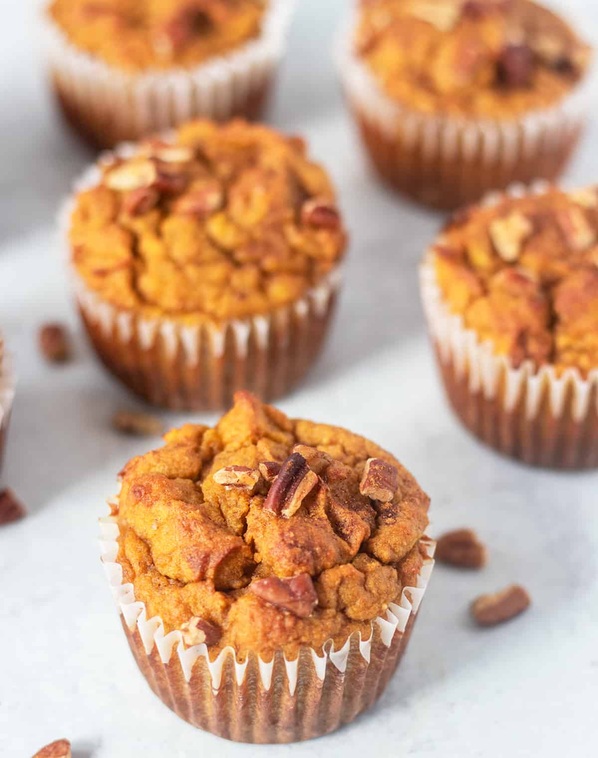 pumpkin muffins topped with pecans and cinnamon