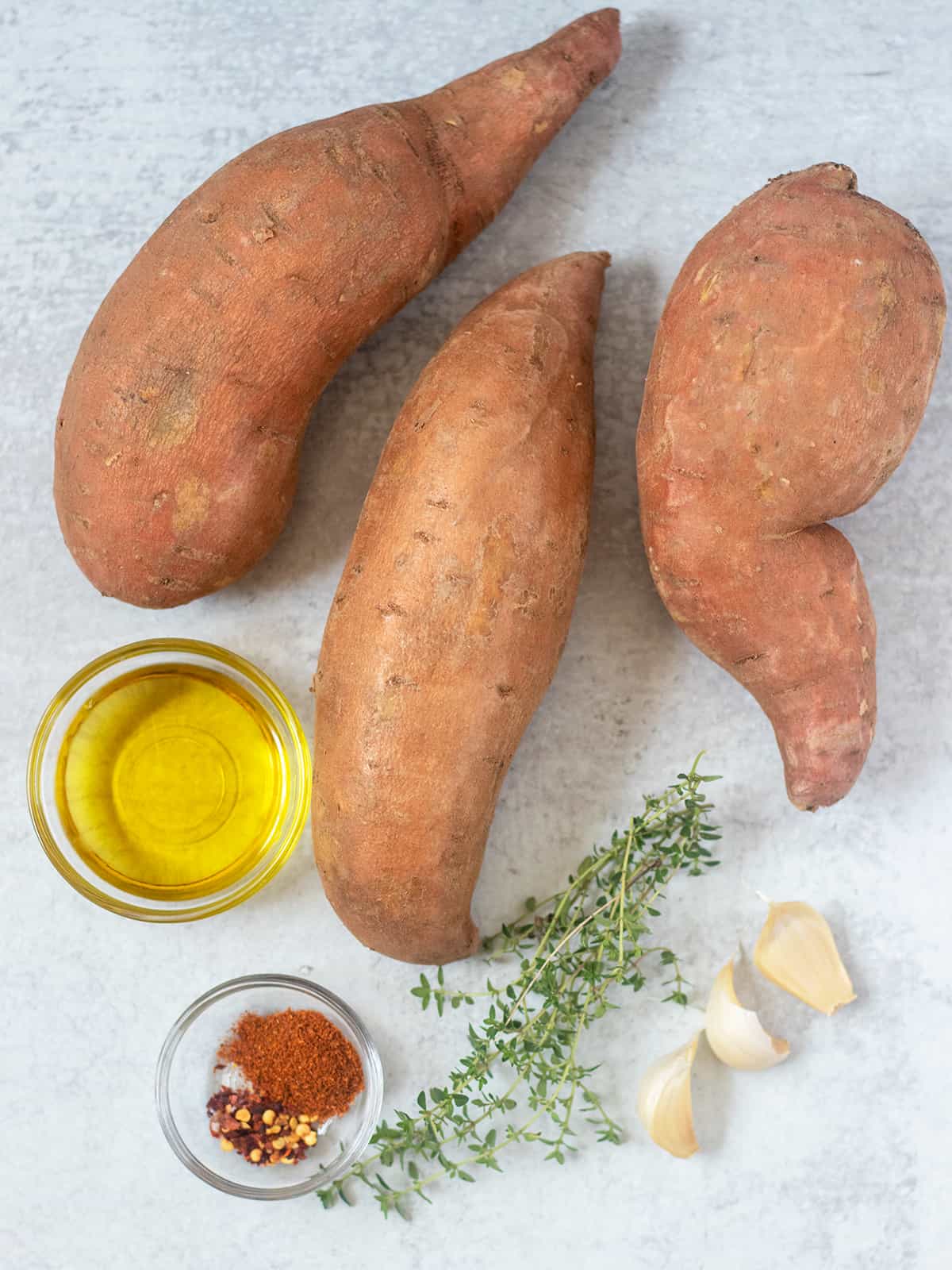 sweet potatoes, olive oil, fresh thyme, garlic cloves, seasonings