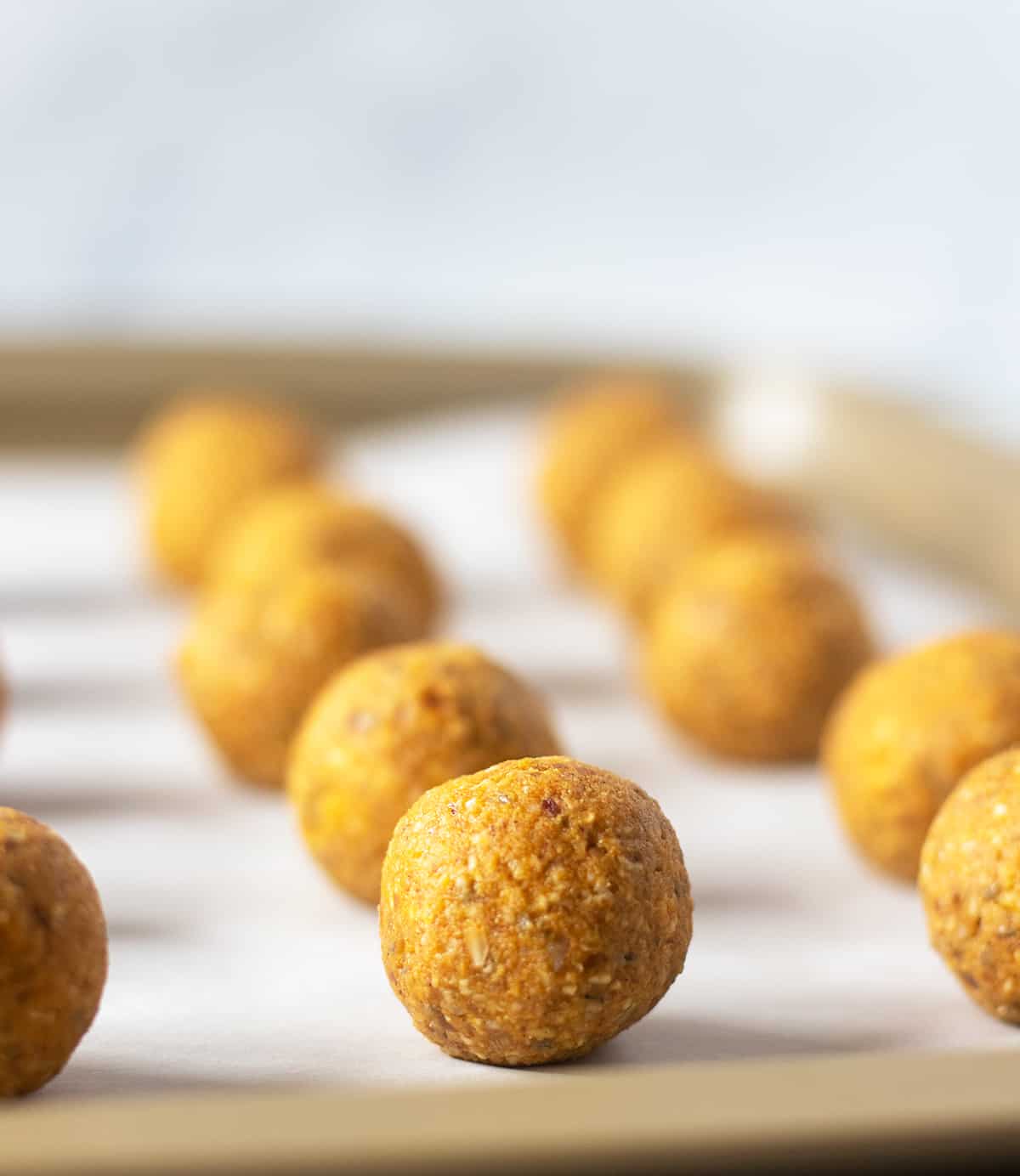 pumpkin pie date energy balls on a parchment lined tray