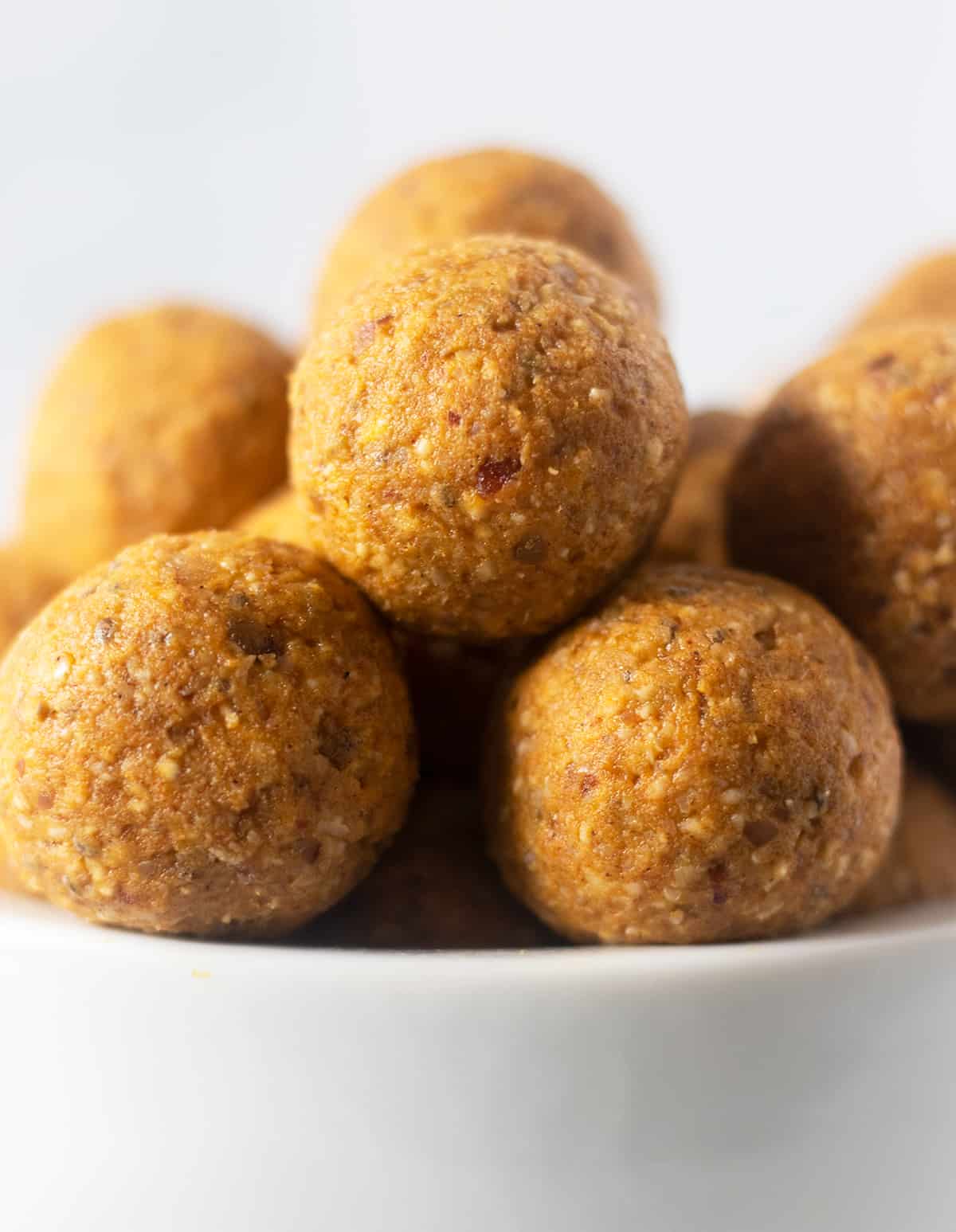 pumpkin pie energy balls stacked in a white bowl