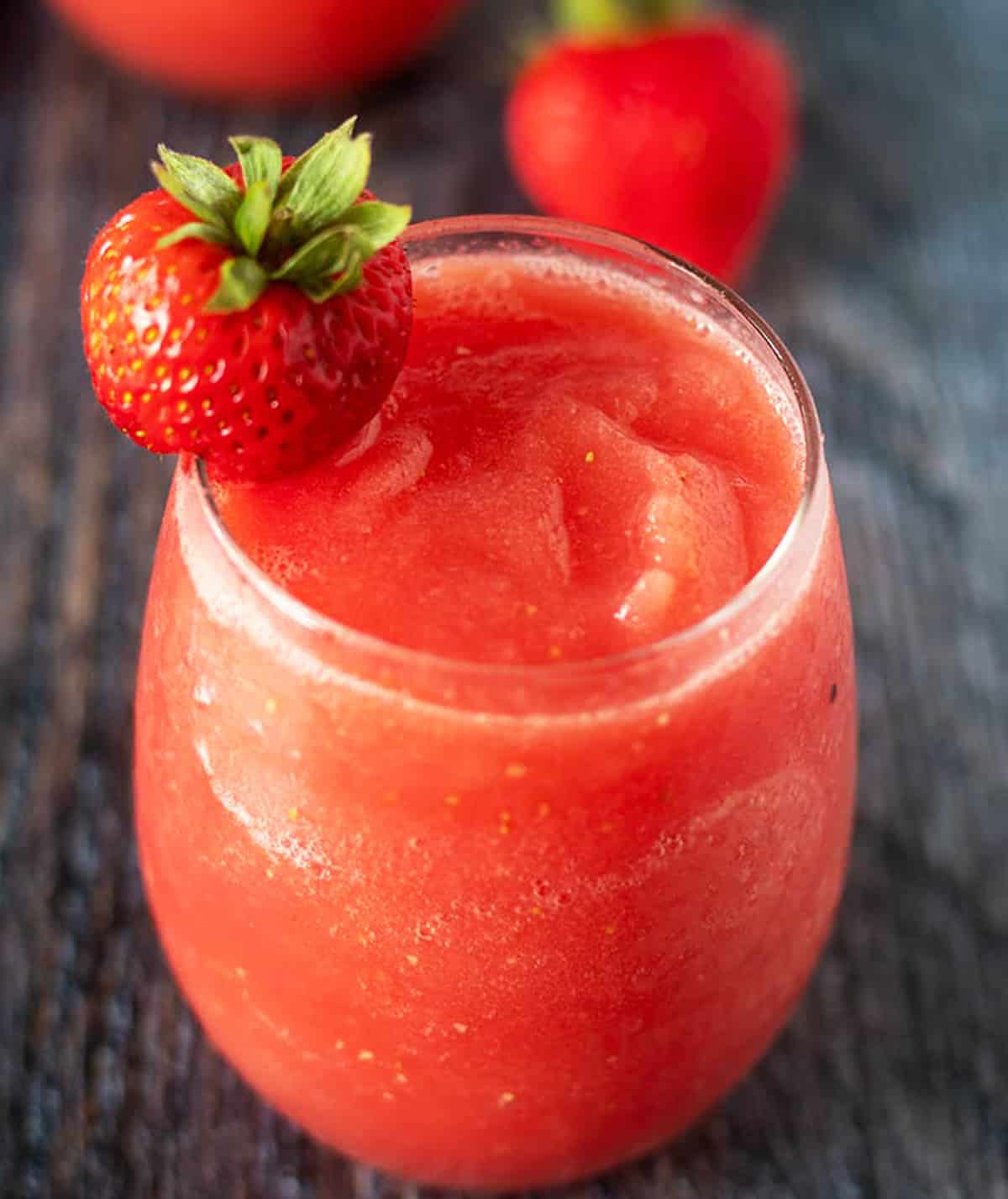 Watermelon Strawberry Wine Slushies in a glass garnished with a strawberry.