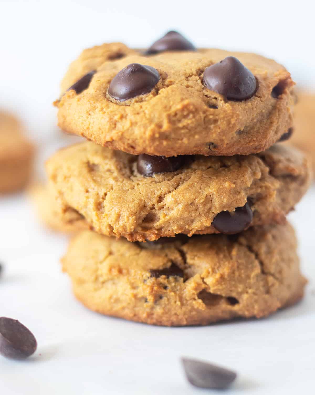 three coconut flour chocolate chip cookies stacked on top of each other.