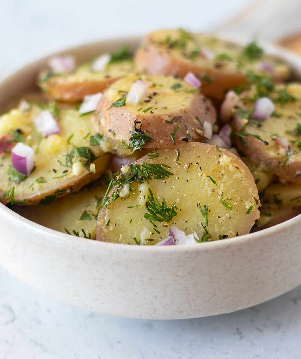 lemon dill potato salad in a white serving bowl.