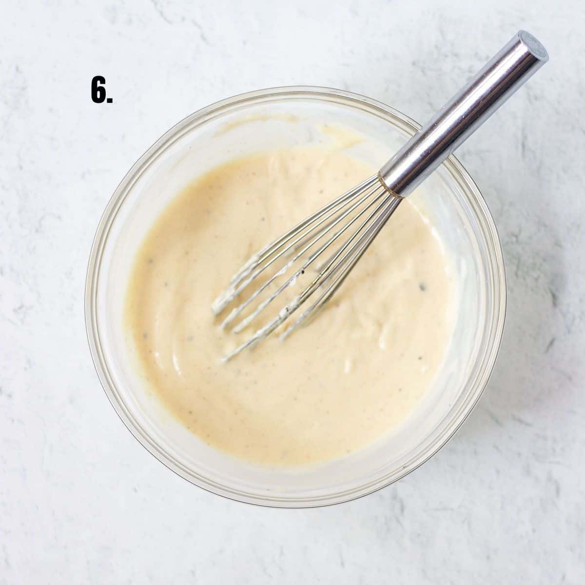honey mustard dressing for coleslaw mixed together in a mixing bowl.