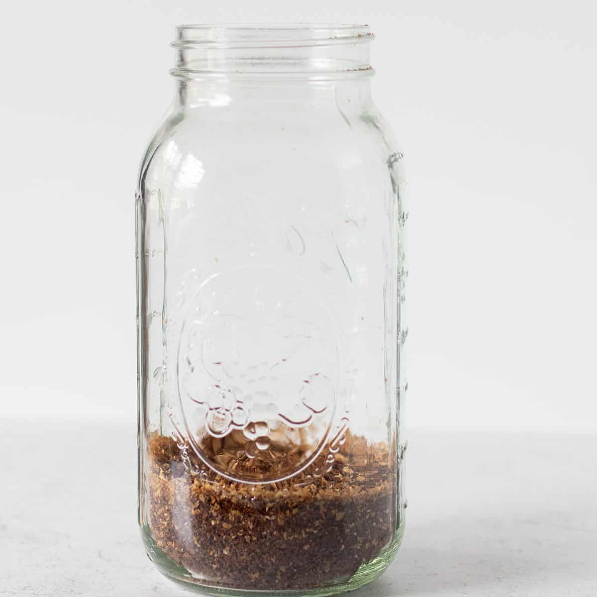 coffee grinds in a large mason jar