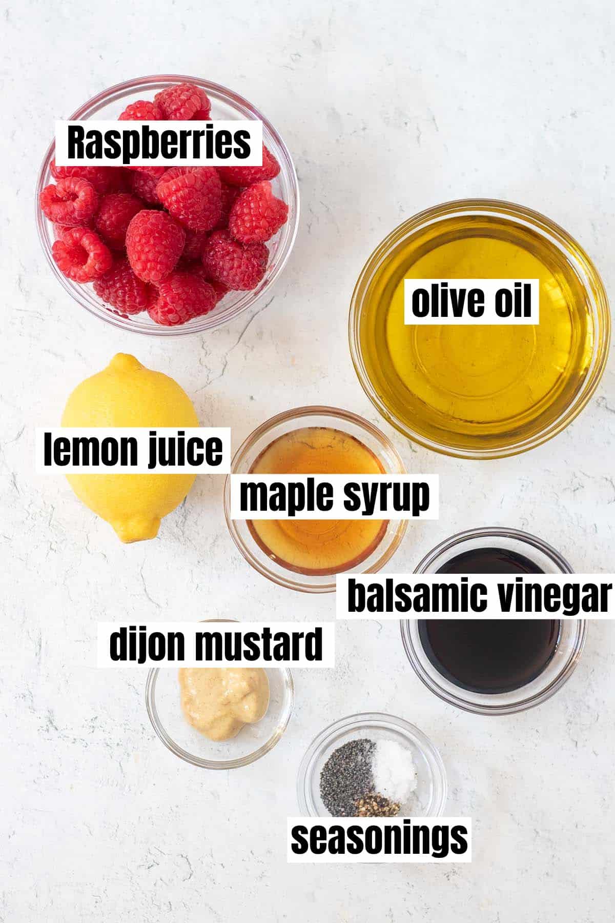 ingredients for raspberry vinaigrette which include raspberries, olive oil, lemon juice, maple syrup, balsamic vinegar, dijon mustard and seasonings
