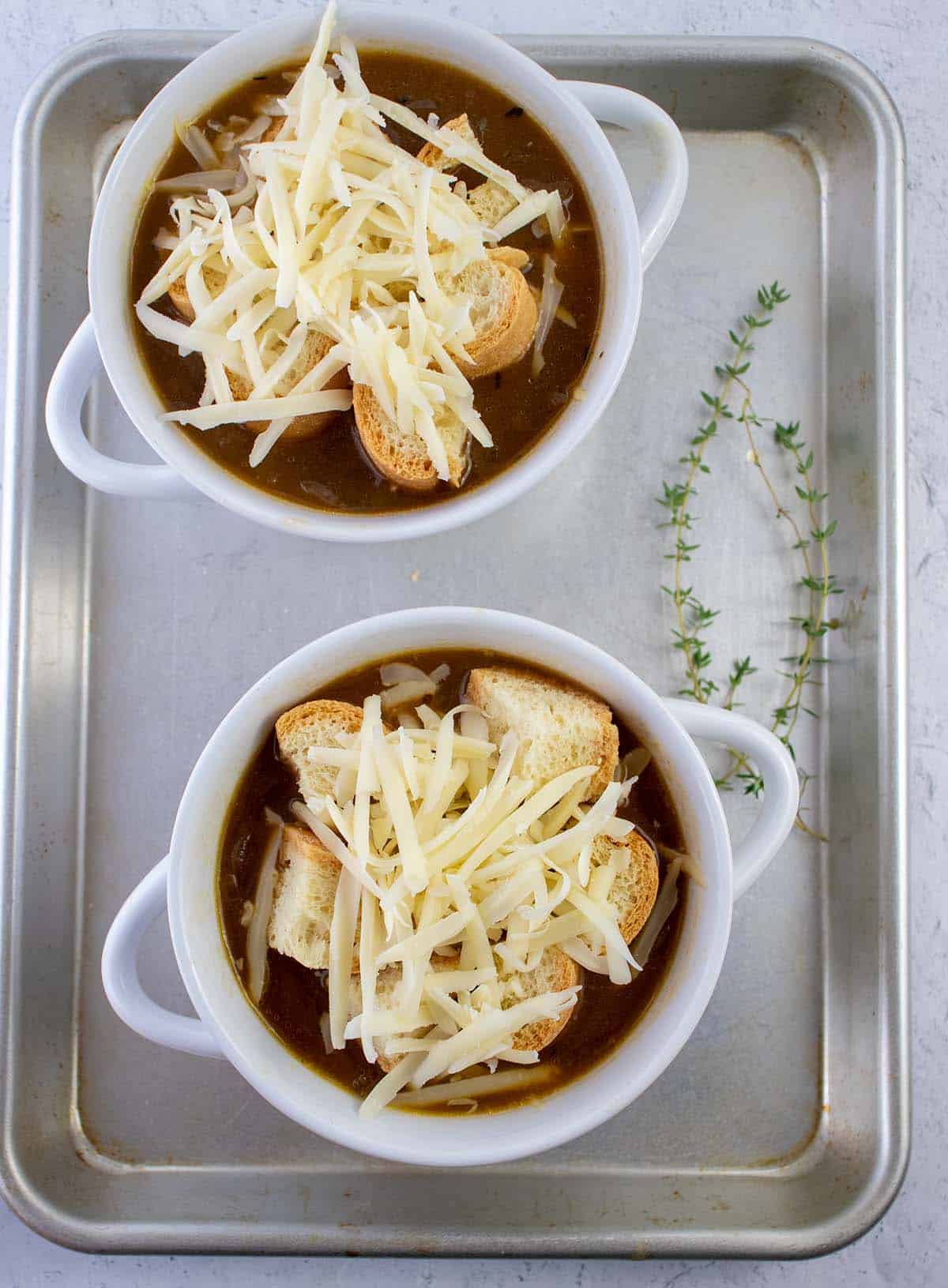 Vegetarian french onion soup topped with croutons and cheese prior to melting.