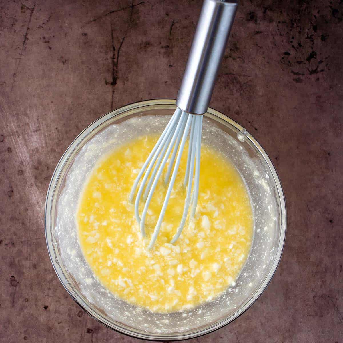 Melted butter and cream cheese blended together in a mixing bowl.