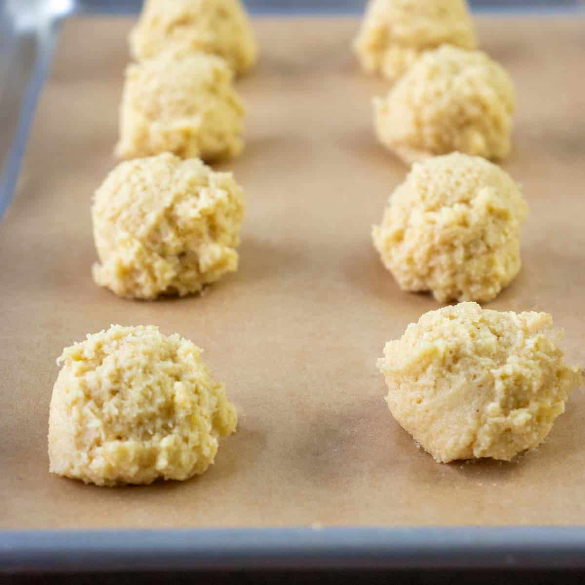 biscuits dropped on parchment lined baking pan with cookie scoop prior to baking.