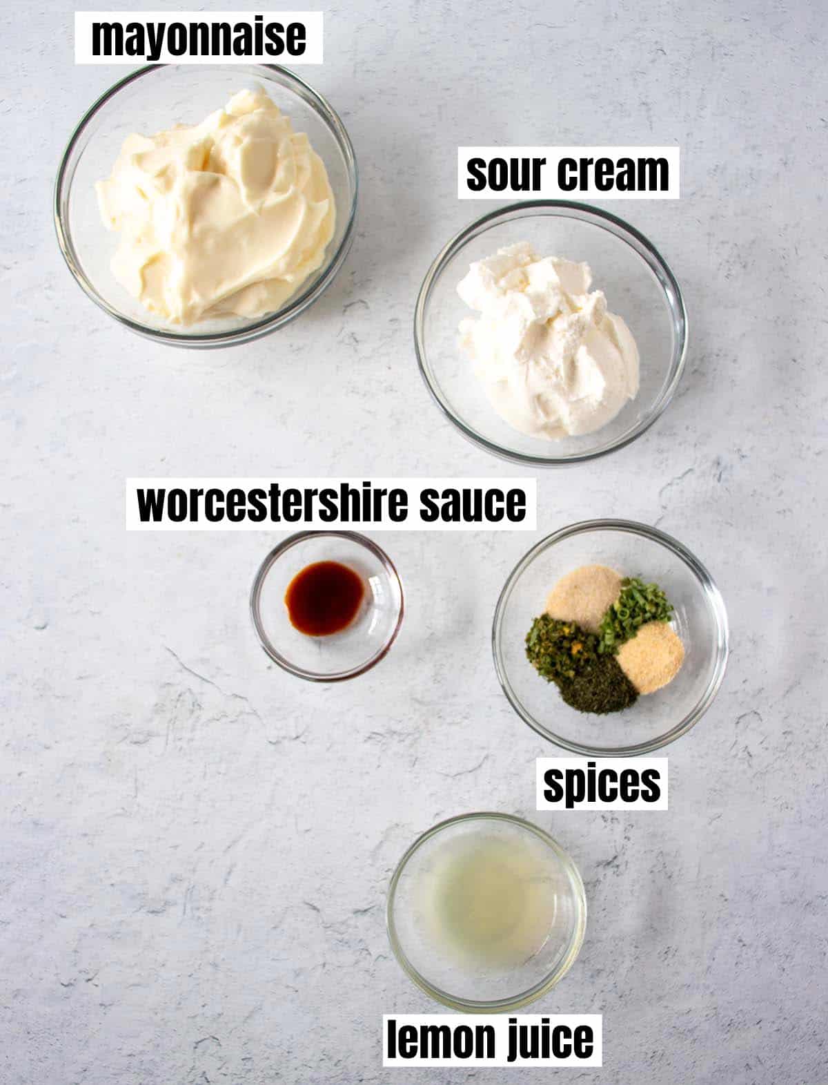 ingredients in homemade ranch dip including mayo, sour cream, worcestershire sauce, spices, and lemon juice.