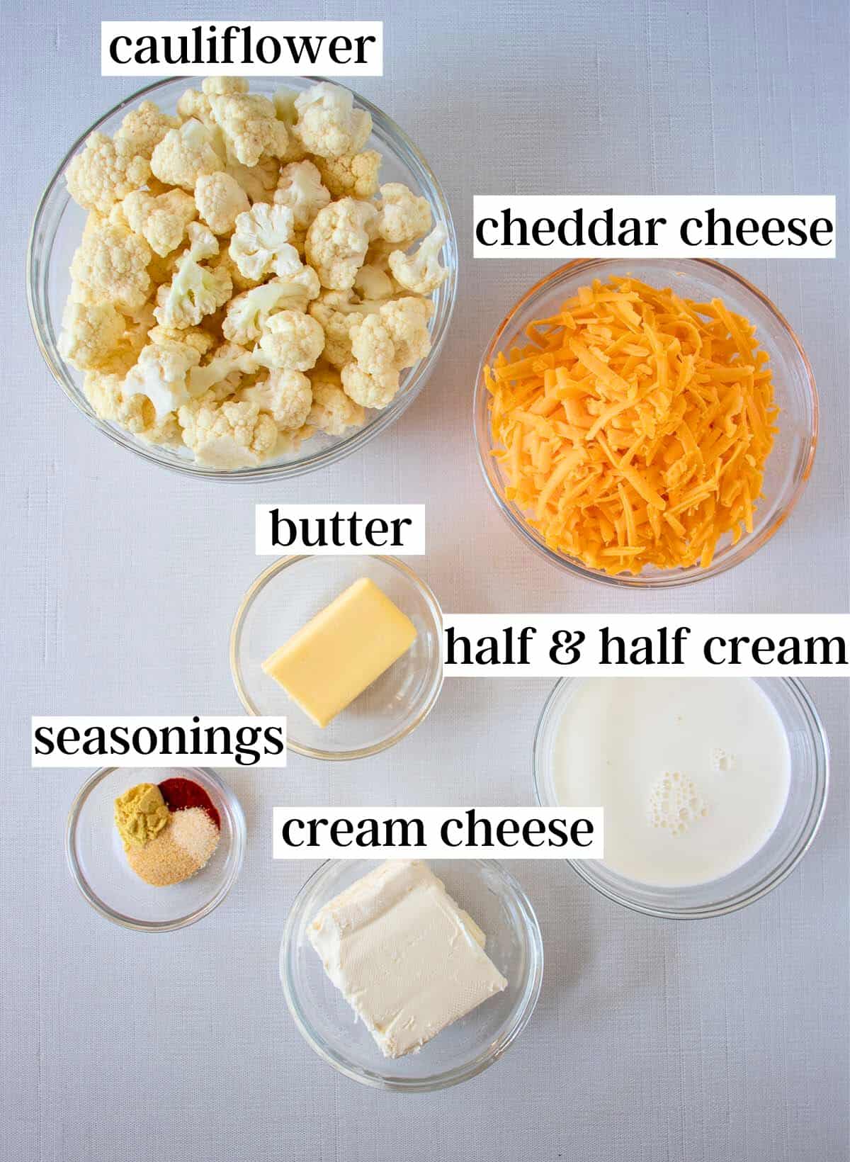 Ingredients for keto cauliflower mac and cheese. Cauliflower florets, cheddar cheese, butter, half & half cream, seasonings, & cream cheese.